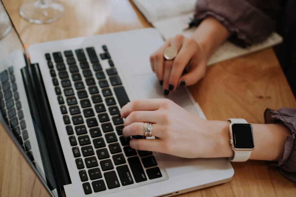 hand of a woman typing on her  laptop